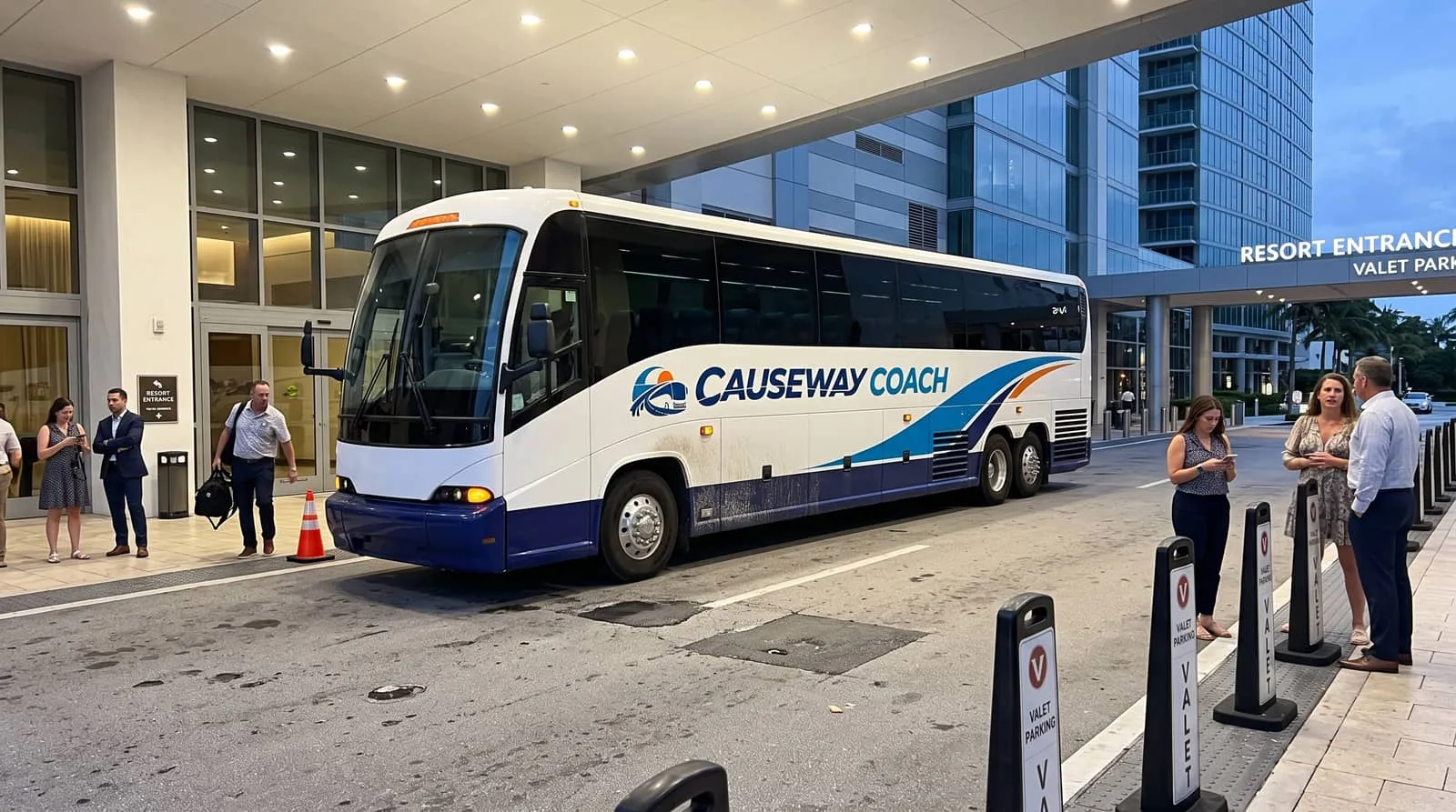 Causeway Coach motorcoach at an evening entertainment venue entrance in South Florida